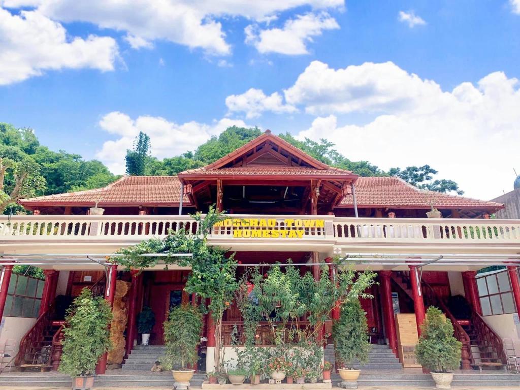 a building with a balcony with plants on it at Moc Chau Town - Homestay in Mộc Châu