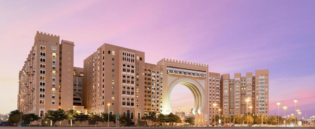 
a large building with a clock on it at Oaks Ibn Battuta Gate Dubai in Dubai
