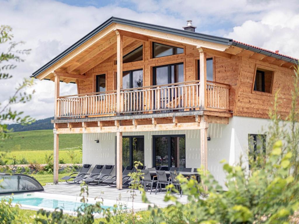 a house with a wrap around deck and a pool at Chalet Alpenblick, Inzell in Inzell