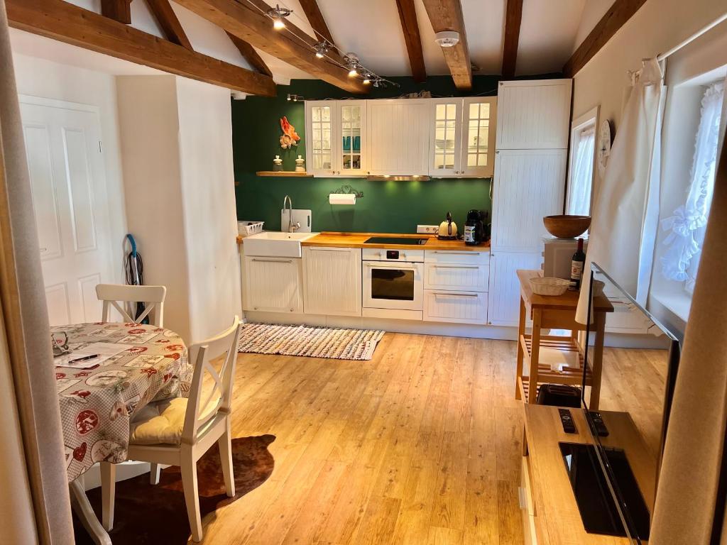 a kitchen with white cabinets and a green wall at Ferienwohnung Giacomelli 2 in Rottach-Egern