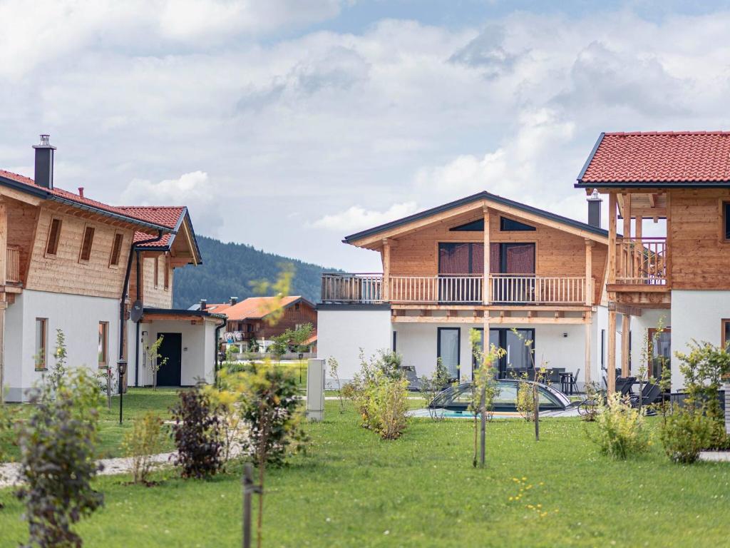 eine Gruppe von Häusern in einem Hof mit einem Rasenplatz in der Unterkunft Inzell Chalets with private pool in Inzell