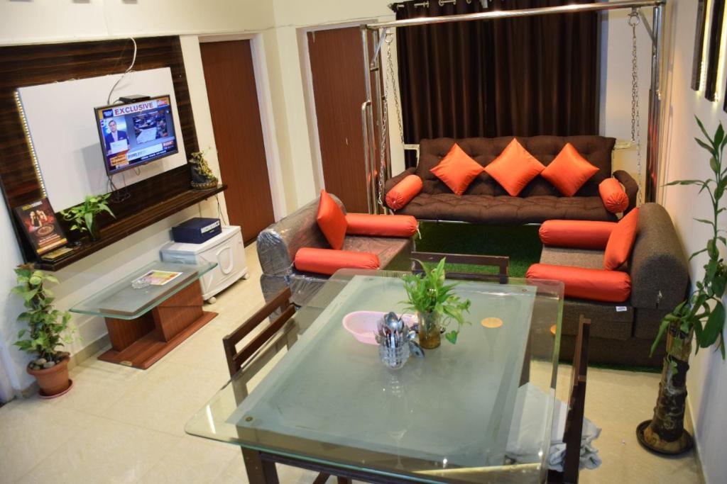 uma sala de estar com um sofá e uma mesa em Premium 2 BHK Green Suites em Arpora