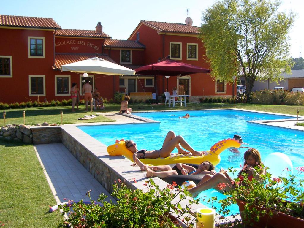 a group of people laying in a swimming pool at Room in Holiday house - Apartment in Farmhouse Casolare dei Fiori in Chiesina Uzzanese