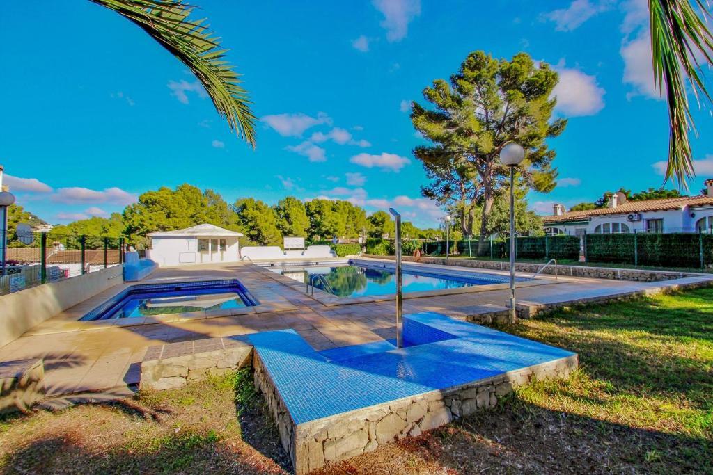 a swimming pool in the backyard of a house at Moraira Park - charming cottage in Moraira in Teulada