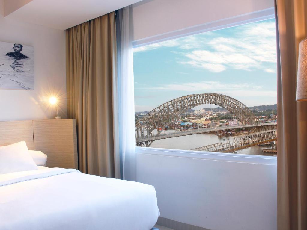Postel nebo postele na pokoji v ubytování HARRIS Hotel Samarinda