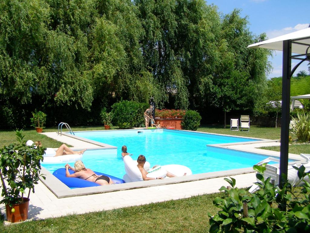 um grupo de pessoas deitadas numa piscina em Room in Farmhouse - Apartment in Farmhouse Casolare dei Fiori em Chiesina Uzzanese