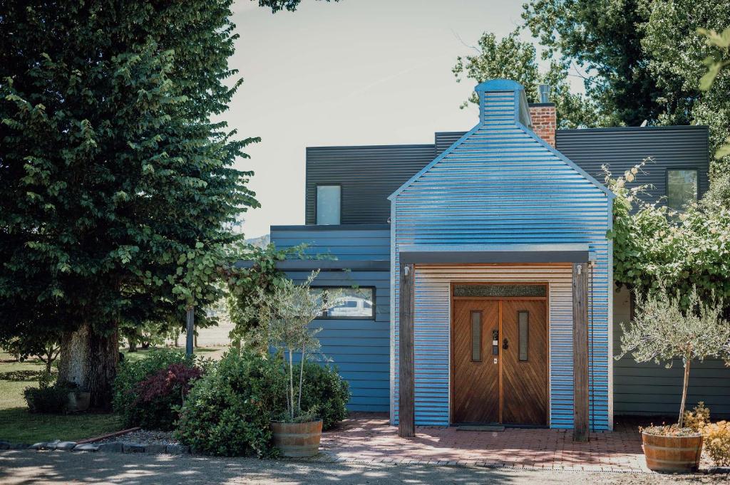 a blue house with a wooden door at Lusso KV in Whitfield