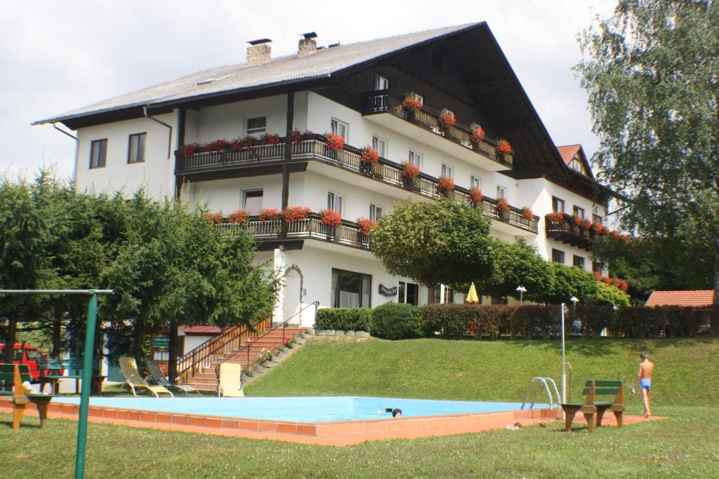 ein Gebäude mit einem Pool vor einem Haus in der Unterkunft Hotel Semriacherhof in Semriach