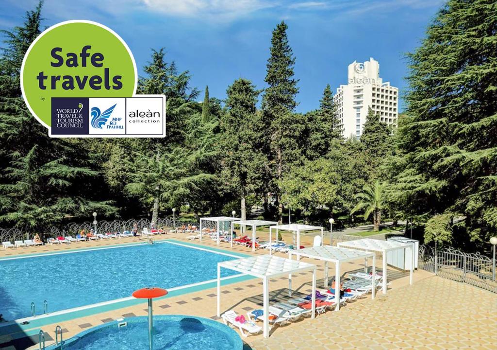 a hotel swimming pool with a sign that reads safe travels at Alean Family Resort & SPA Sputnik 4* Ultra All Inclusive in Sochi