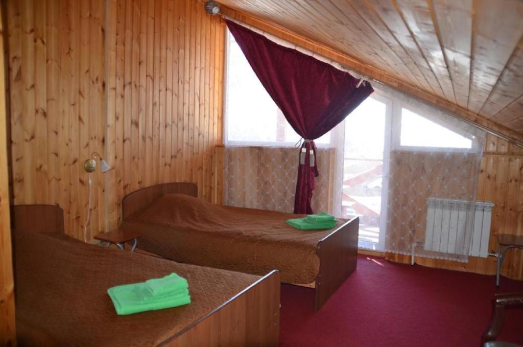 1 dormitorio con 2 camas y ventana en Дом Гавань Байкала, en Listvyanka