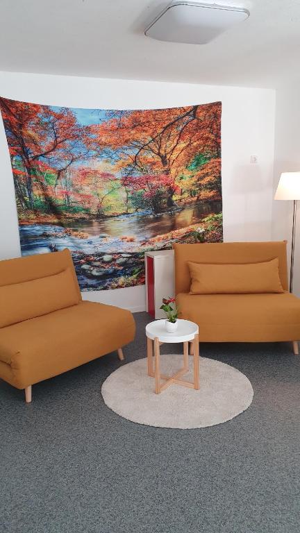 two couches and a table in a room with a painting at Gästezimmer Carmen in Schwendi