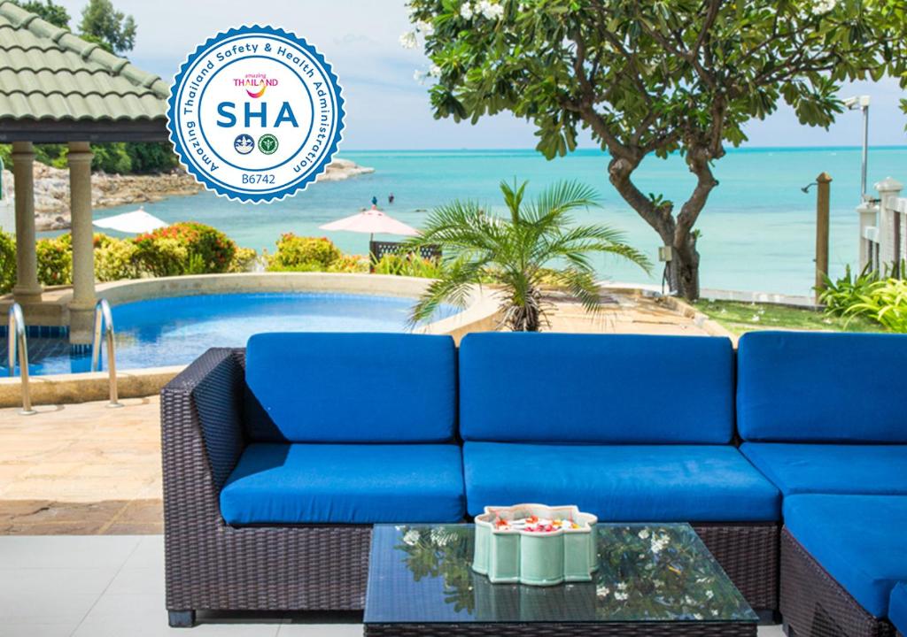 un sofá azul sentado frente a una piscina en Idyllic Samui Beach Villa Resort, en Choeng Mon Beach