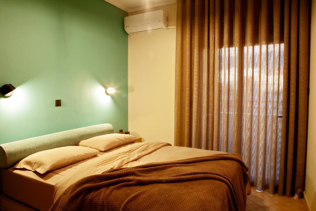 uma cama num quarto com uma parede verde em Designer apartments close to the center + free parking em Tessalônica