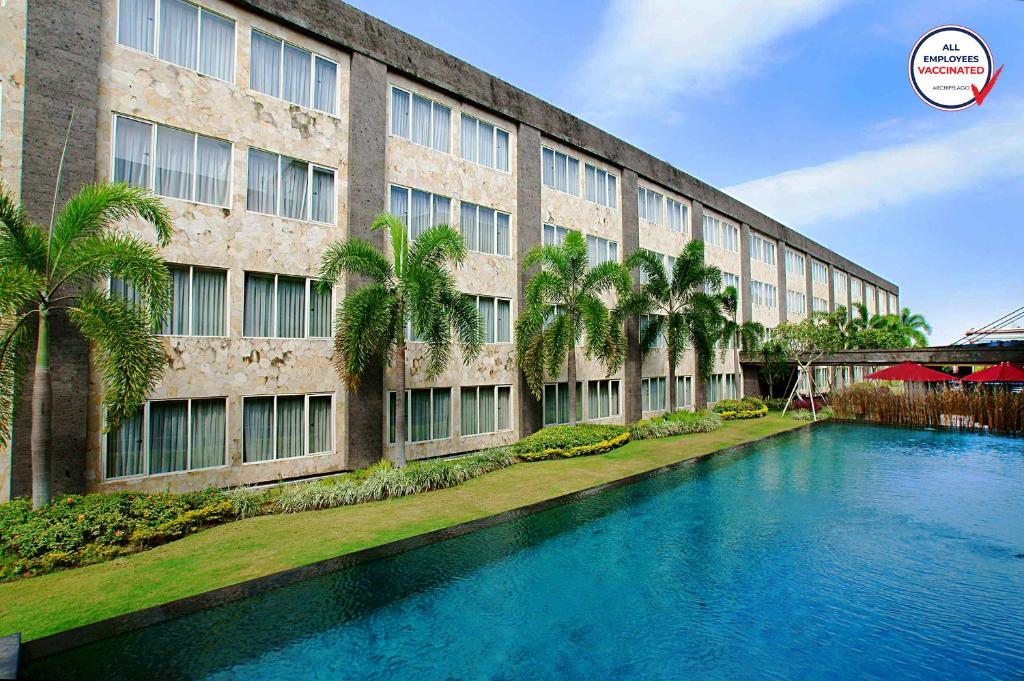 a building with a swimming pool in front of a building at ASTON Denpasar Hotel & Convention in Denpasar