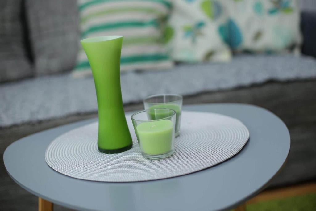 een groene vaas en twee glazen op een tafel bij Apartman Green in Lukavica