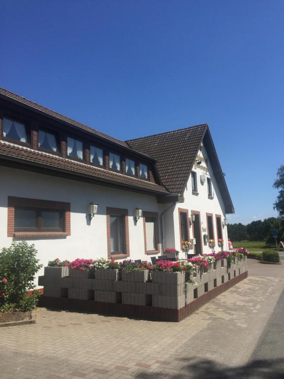 ein weißes Haus mit Blumen auf der Seite in der Unterkunft Landgasthof Dockemeyer in Hollenermoor