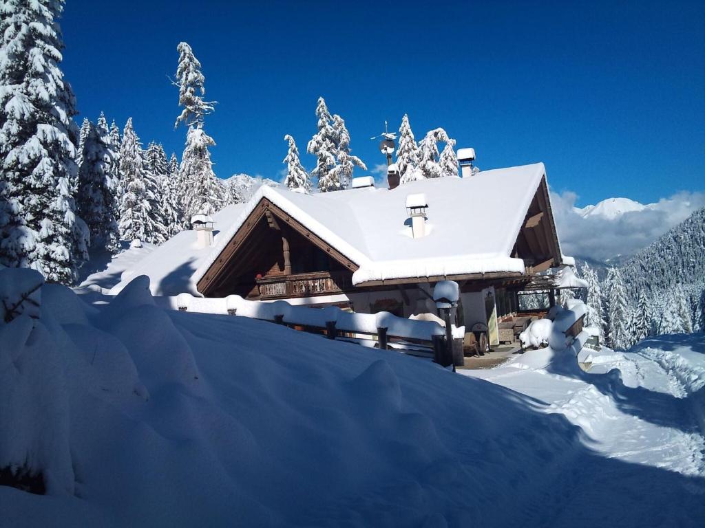 a log cabin covered in snow in the mountains at Quaint alpine hut in the Stubaital with sauna in Neustift im Stubaital