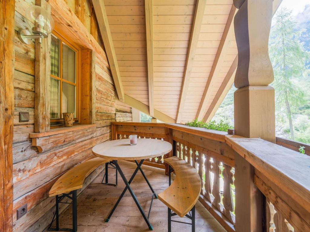 einen Tisch und Stühle auf der Veranda einer Hütte in der Unterkunft Quaint alpine hut in the Stubaital with sauna in Neustift im Stubaital