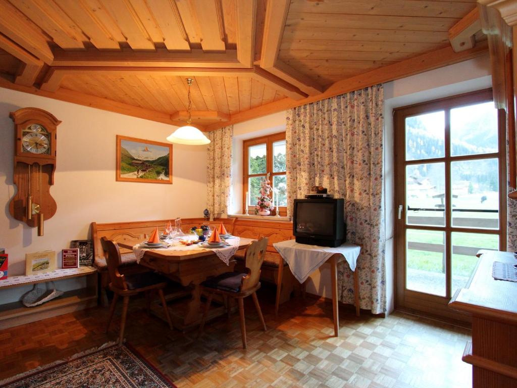 ein Esszimmer mit einem Tisch und einem TV in der Unterkunft Serene Cottage in Neukirchen am Gro venediger in Neukirchen am Großvenediger