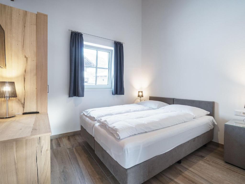 a bedroom with a large bed and a window at Sunny holiday home with sauna in Piesendorf in Piesendorf
