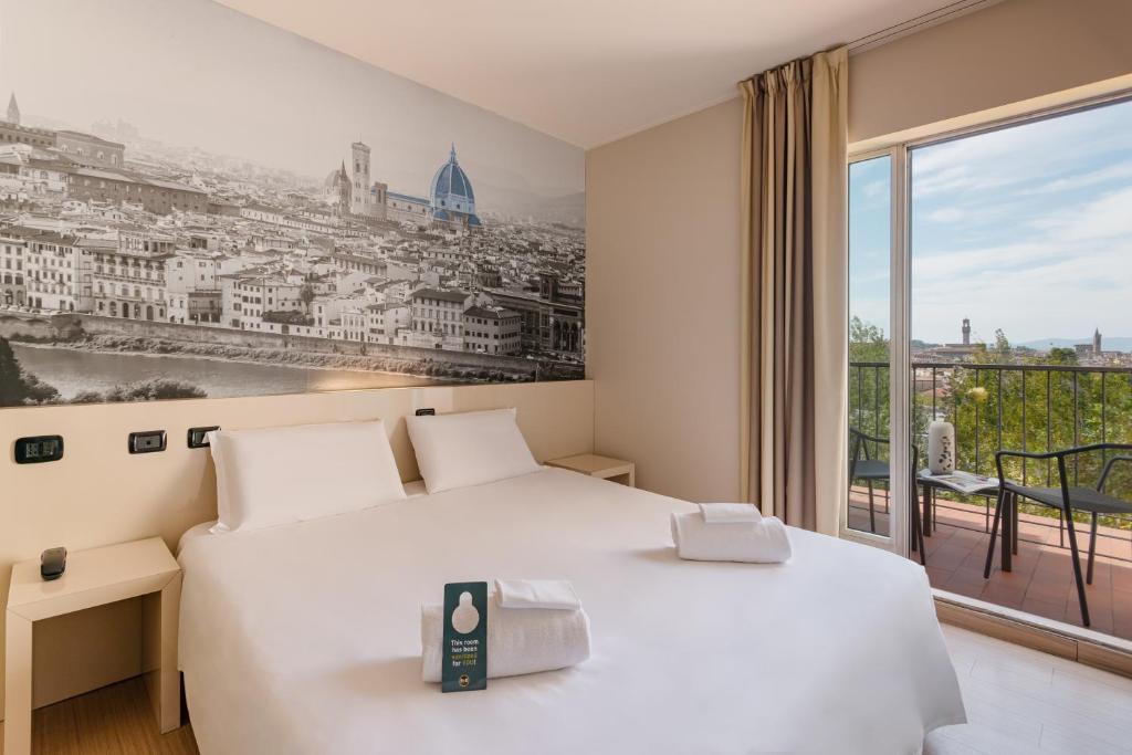 a hotel room with a bed and a painting on the wall at B&B Hotel Firenze City Center in Florence