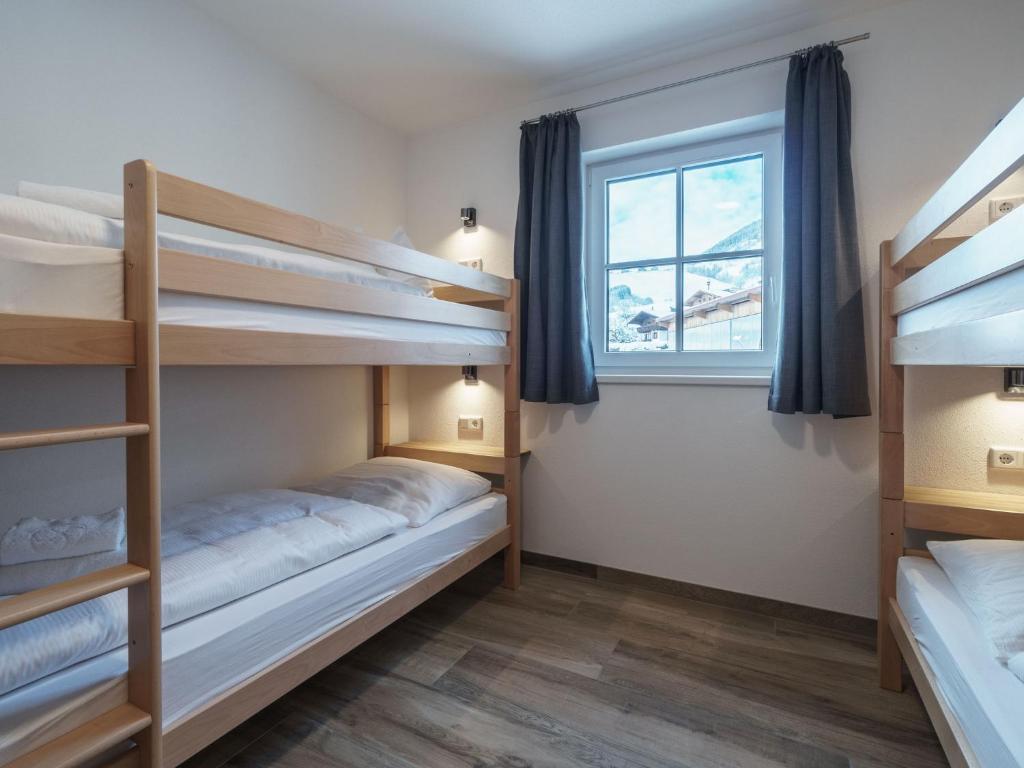 a bedroom with two bunk beds and a window at Sunny holiday home with sauna in Piesendorf in Piesendorf