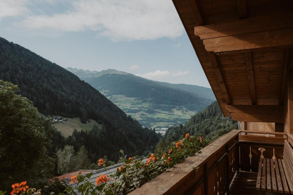 einen Balkon mit Blick auf ein Tal mit Bergen in der Unterkunft Gogererhof App Maria in Ratschings