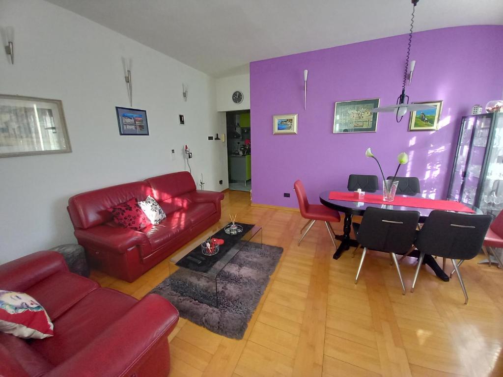 ein Wohnzimmer mit einem roten Sofa und einem Tisch in der Unterkunft Apartman Diana in Split