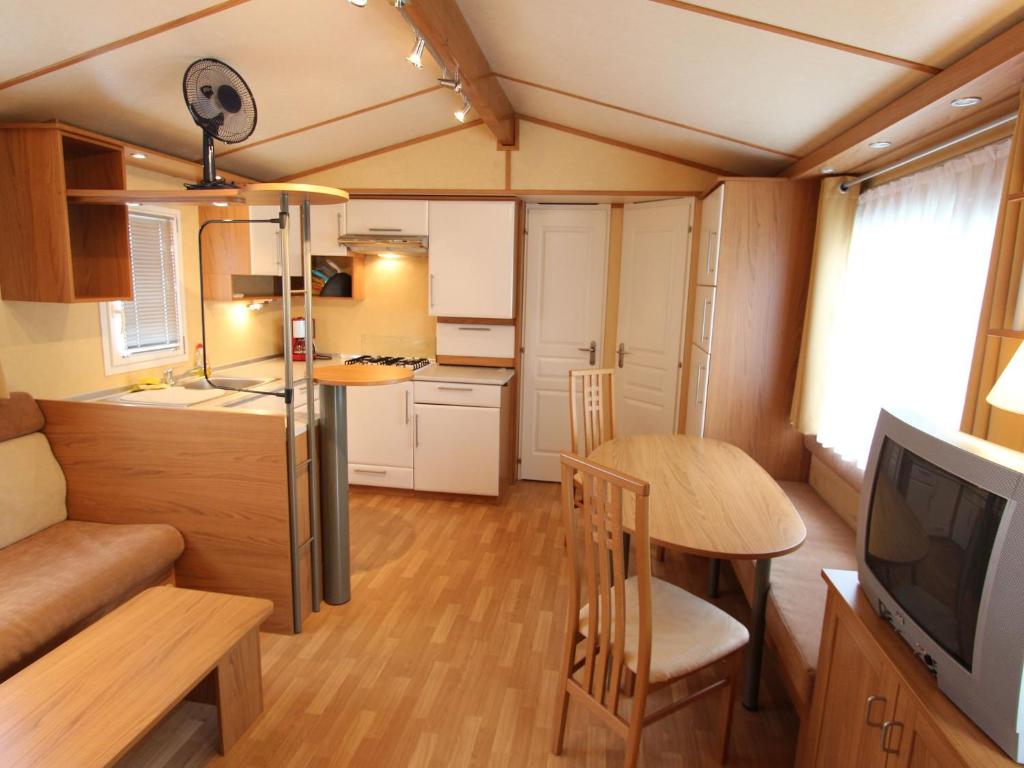 a small kitchen and dining room in a tiny house at Mobile home near Lake Klopeiner See in Sankt Kanzian