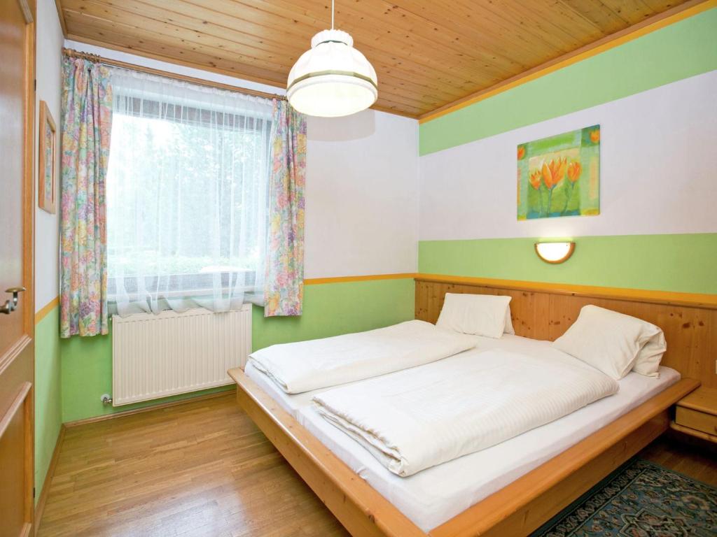 アルテンマルクト・イム・ポンガウにあるWonderful holiday home with mountain viewsの緑と白の壁のベッドルーム1室(ベッド1台付)