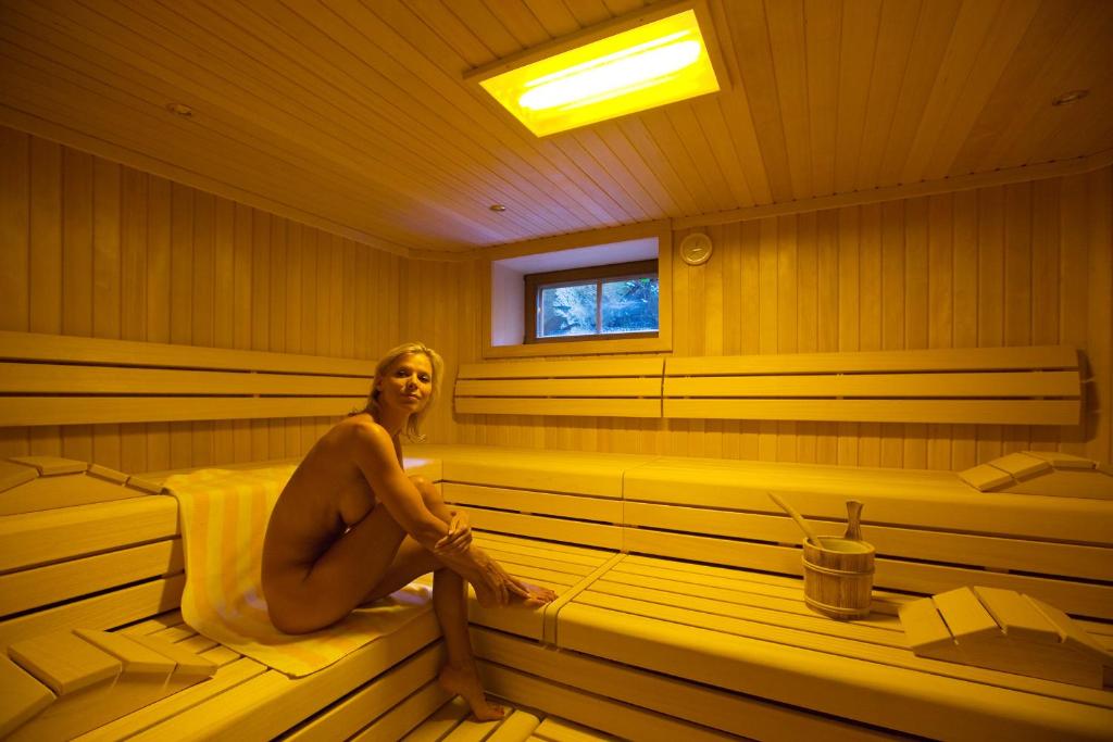 a woman is sitting in a sauna at Hotel Zum Schwarzen Bären in Emmersdorf an der Donau