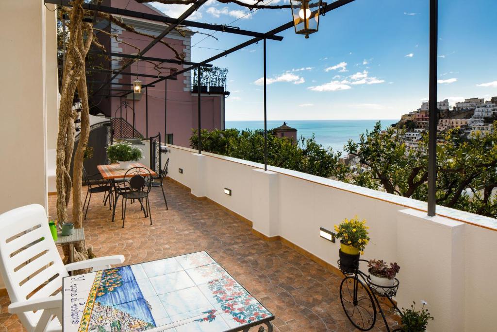 a balcony with a table and chairs and a view of the ocean at YourHome - Relais Il Sogno di Positano in Positano