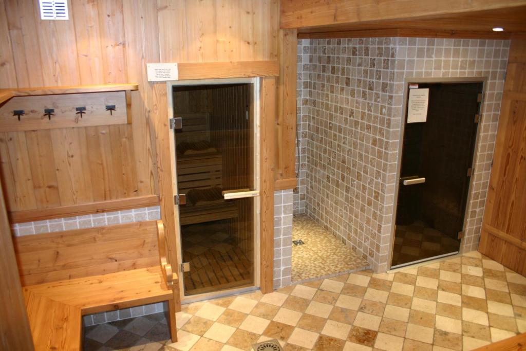 baño con paredes y suelo de madera y 2 puertas en Studio Forclaz Avec Coin Nuit, en Le Grand-Bornand