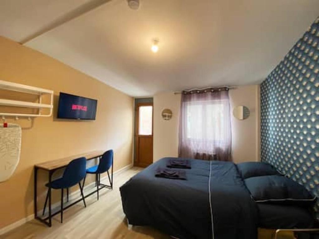 1 dormitorio con cama, escritorio y sofá en NG SuiteHome - Lille I Roubaix Rémy Cogghe - Studio - Netflix - Wifi en Roubaix