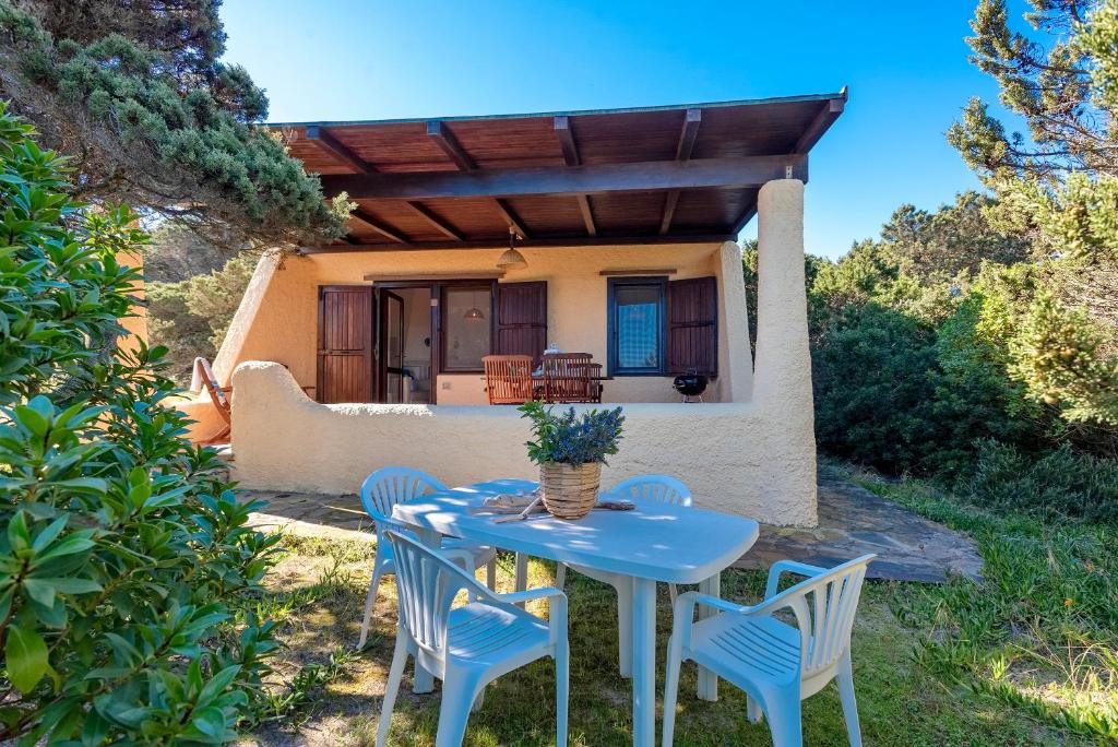 a blue table and chairs in front of a house at SARDINIA RE - Villa Pelosa in Stintino