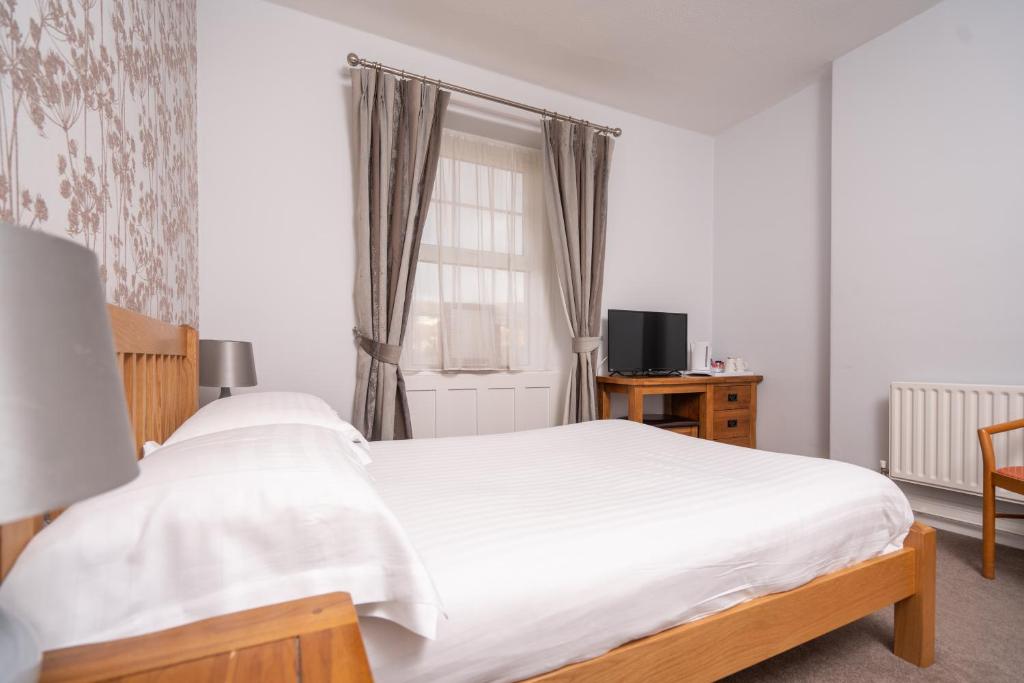 a bedroom with a white bed and a window at Lauriston Hotel in Weston-super-Mare