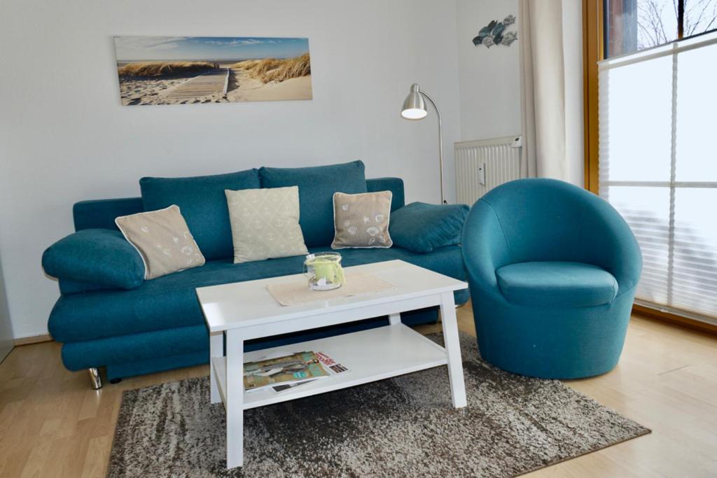 ein Wohnzimmer mit einem blauen Sofa und einem Tisch in der Unterkunft Kajüte 5 in Dahme
