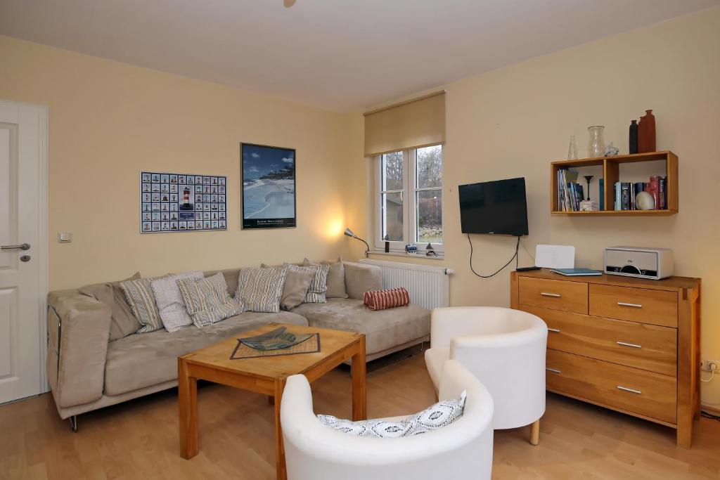 ein Wohnzimmer mit einem Sofa und einem Tisch in der Unterkunft Ferienhaus Am Fulgenbach in Klein Bollhagen