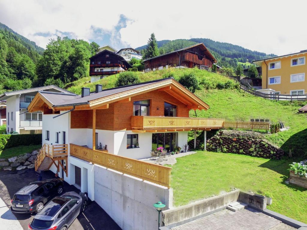 a house on a hill with cars parked in a parking lot at Penthouse in ski resort in Piesendorf in Piesendorf