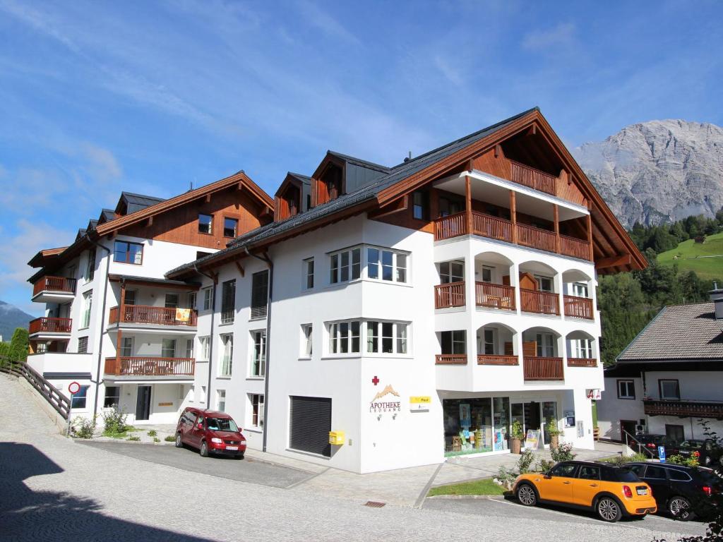a white apartment building with a brown roof at Holiday apartment in Leogang near the ski area in Leogang