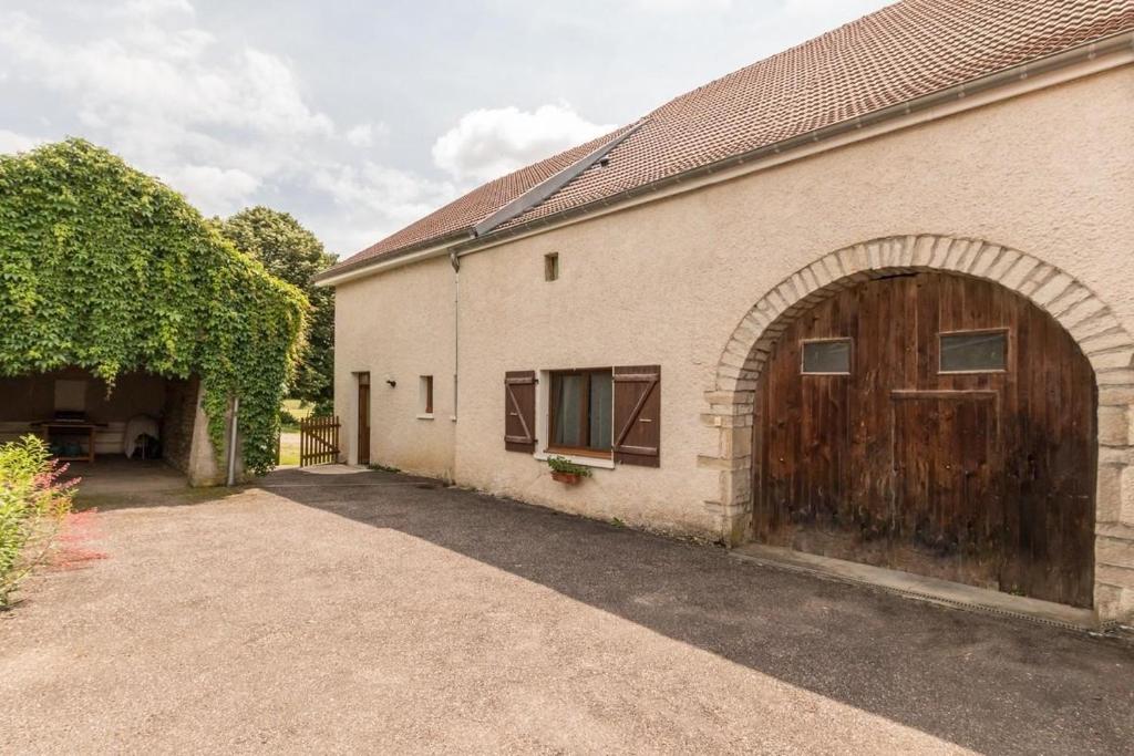 un gran edificio de ladrillo con una gran puerta de madera en Gîte à Confracourt, en Confracourt