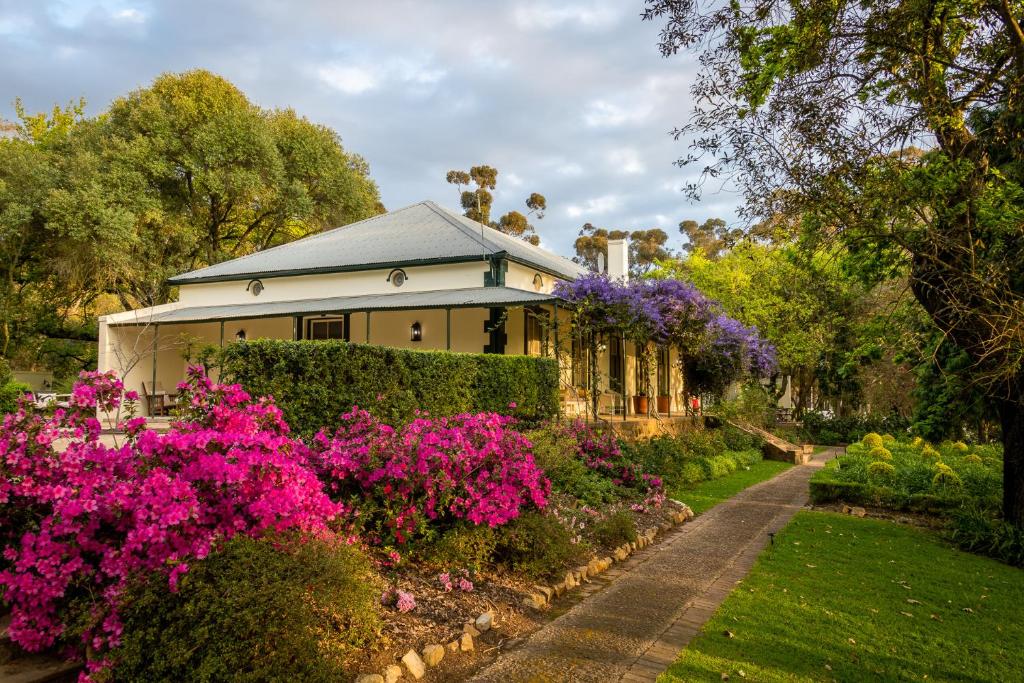 uma casa com flores em frente em Bartholomeus Klip Farmhouse em Hermon