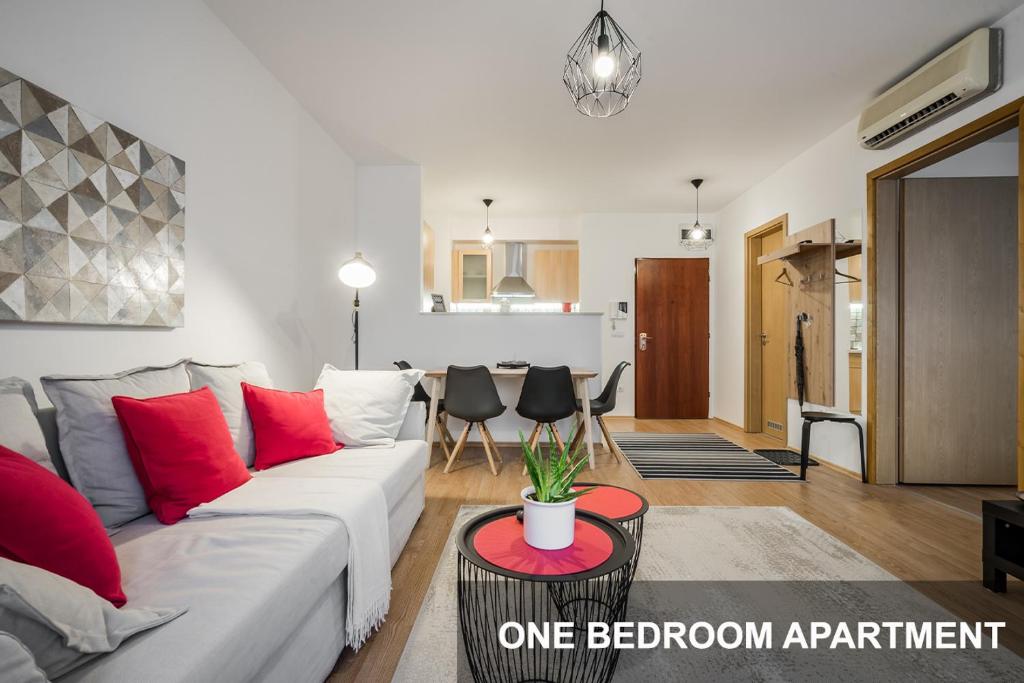 a living room with a white couch and red pillows at BpR City Lodge Apartments in Budapest