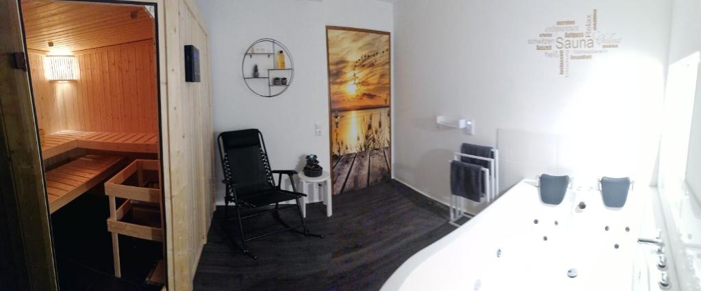 Cette chambre comprend un miroir, un bureau et une chaise. dans l'établissement Ferienwohnung Christine mit Sauna und Whirlpool, à Utzerath