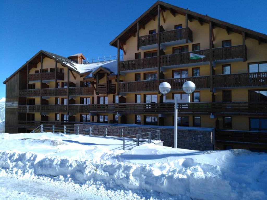 Un gran edificio con nieve delante. en RISOUL 1850, en Risoul