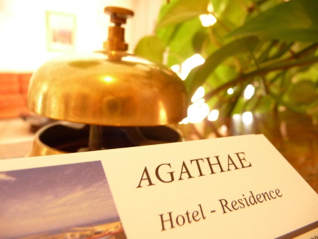 a sign that reads acatatha hotel residence next to a lamp at Agathae Hotel & Residence in Scoglitti