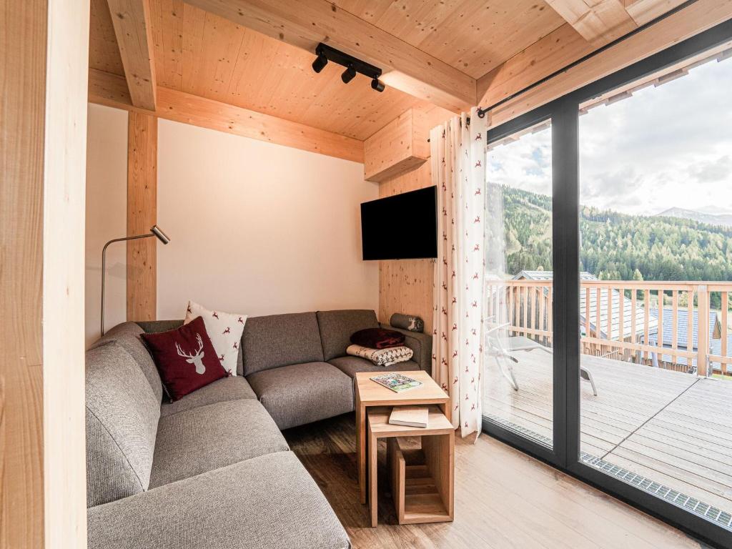 een woonkamer met een bank en een groot raam bij Chalet in Hohentauern Styria with sauna in Hohentauern