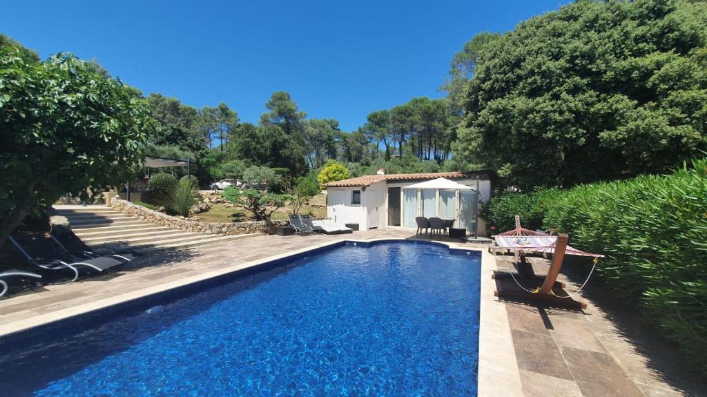 a swimming pool in front of a house at Gîte Les Grillons in Draguignan