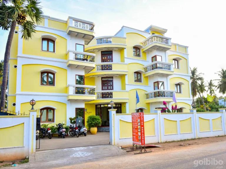 a yellow building with motorcycles parked in front of it at HOTEL PRISO in Kālapettai