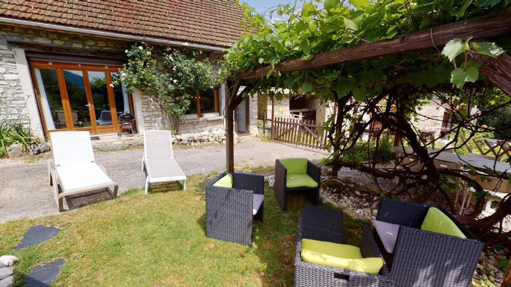 a group of chairs sitting on the grass in front of a house at L'Horizon in La Burbanche